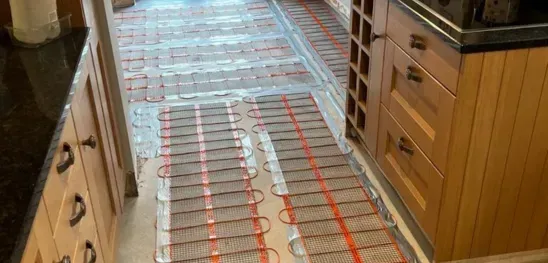 A kitchen with wooden cabinets and a heating mat on the floor.