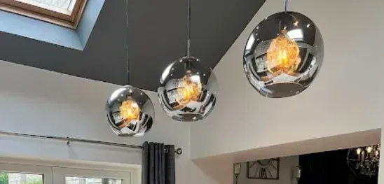 Three pendant lights are hanging from the ceiling in a living room.